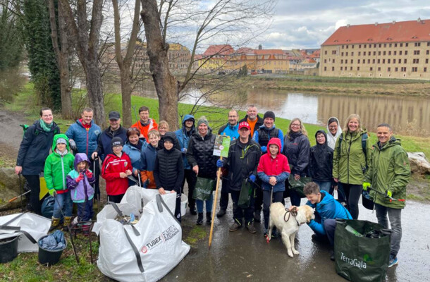 Eine Gruppe von Menschen hat sich versammelt, um den Wald zu putzen und von Müll zu befreien.