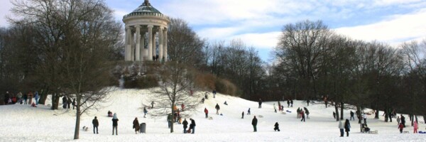 Schneebedeckter und gut besuchter Rodelberg.
