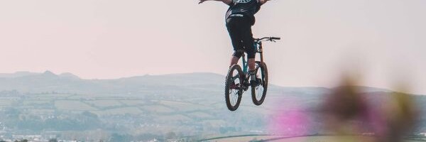 Biker springt über Hügel in einem naturnahen Bikerpark