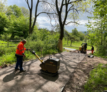 Bauarbeiter glättet Fläche mit Rüttelplatte
